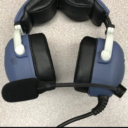 Casque aviation à double coquille avec micro à perche, posé à plat